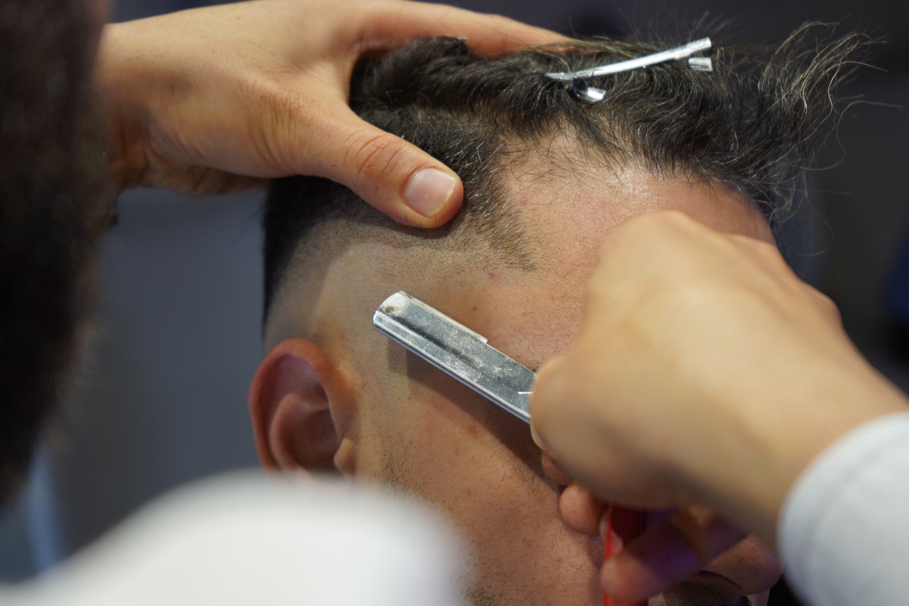 Barber using a razor on a fade