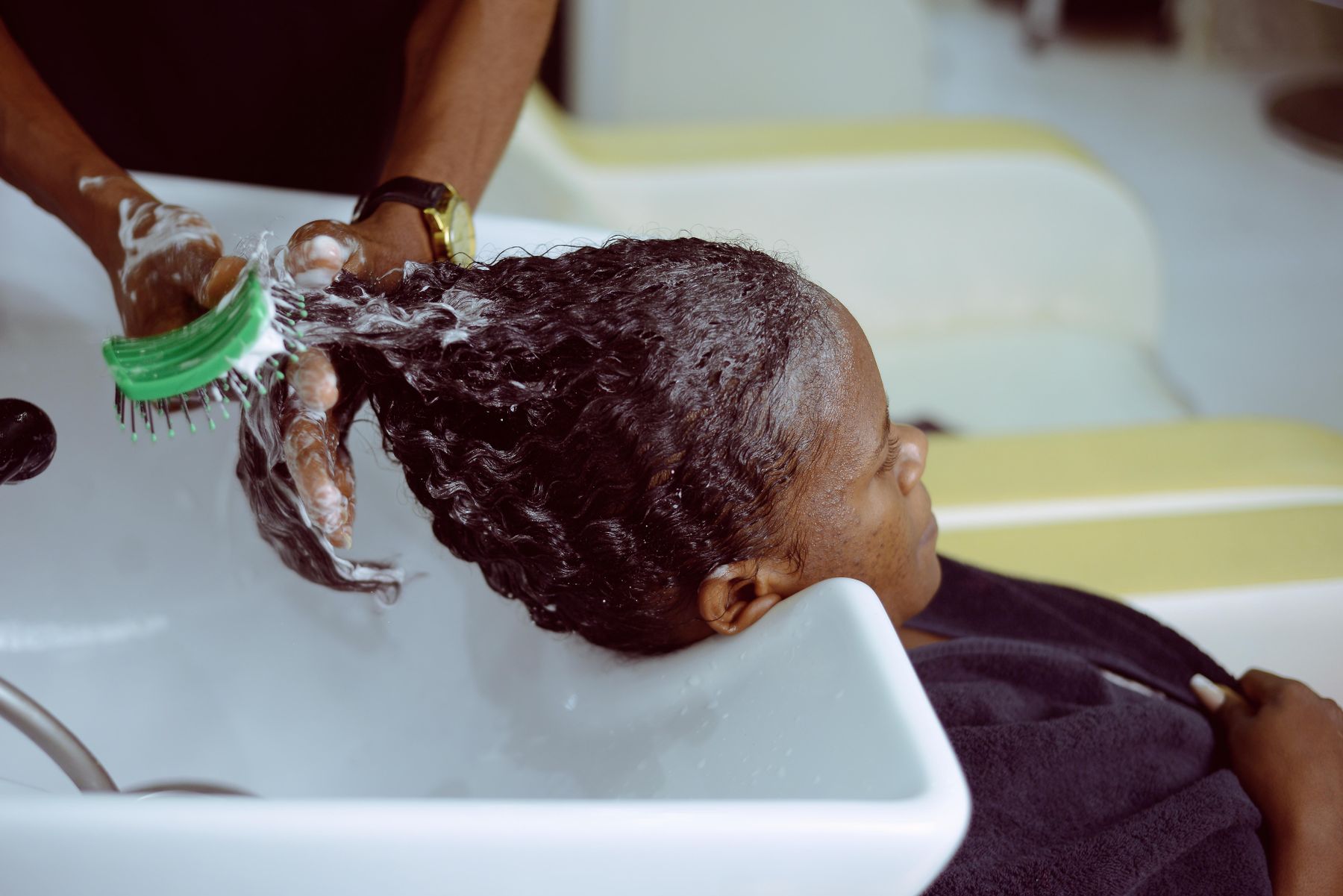 Client having her hair washed at a basin